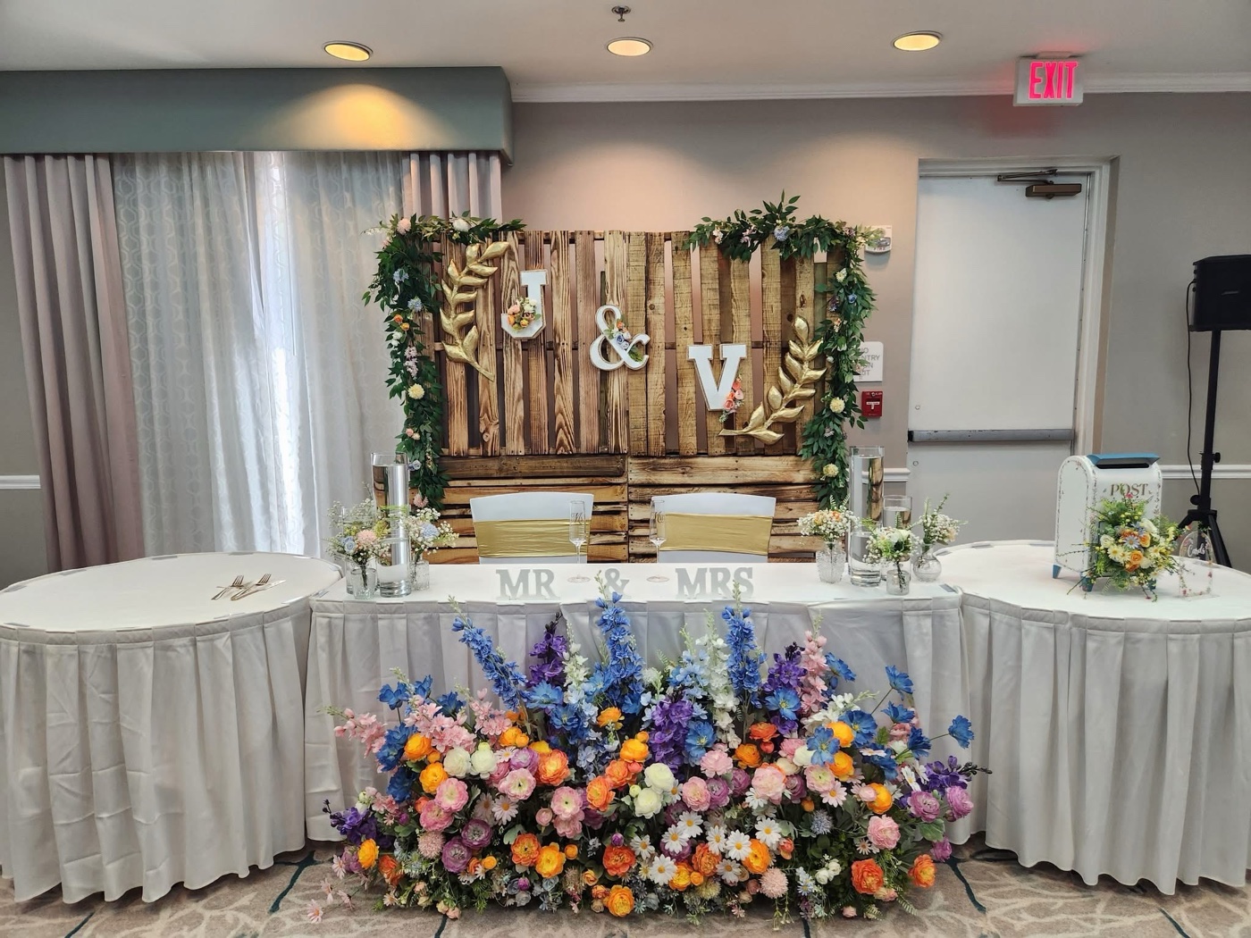 Wedding sweetheart table with flowers, candles, and gold seating