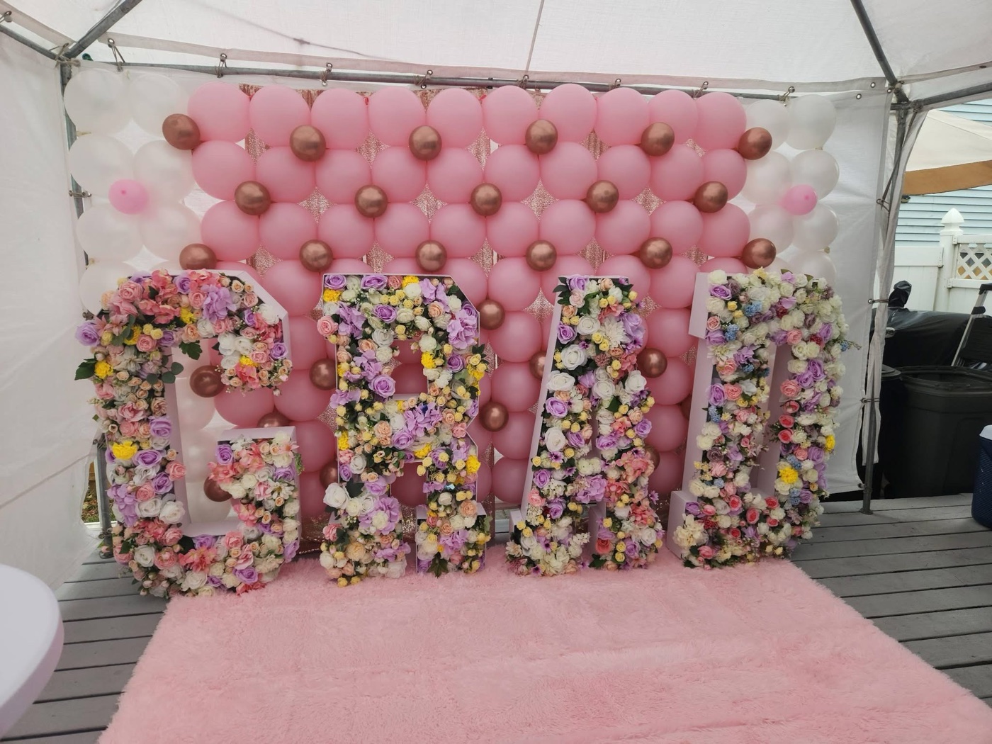 Pink graduation balloon wall and floral celebration backdrop