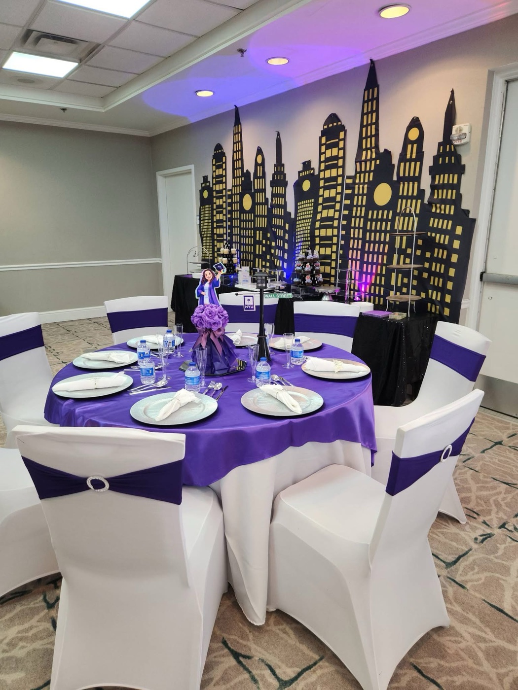 Purple NYU themed event table with city backdrop