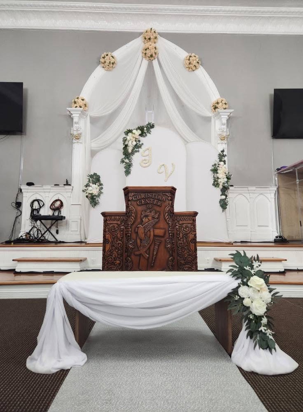 White ceremony altar with floral arrangements