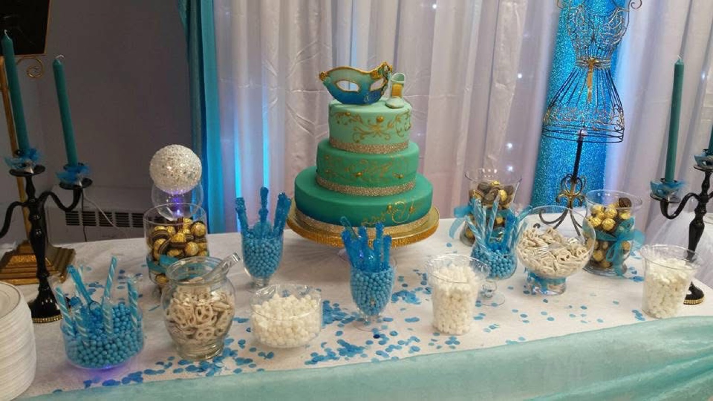 Teal dessert table with cake, cupcakes, and party treats